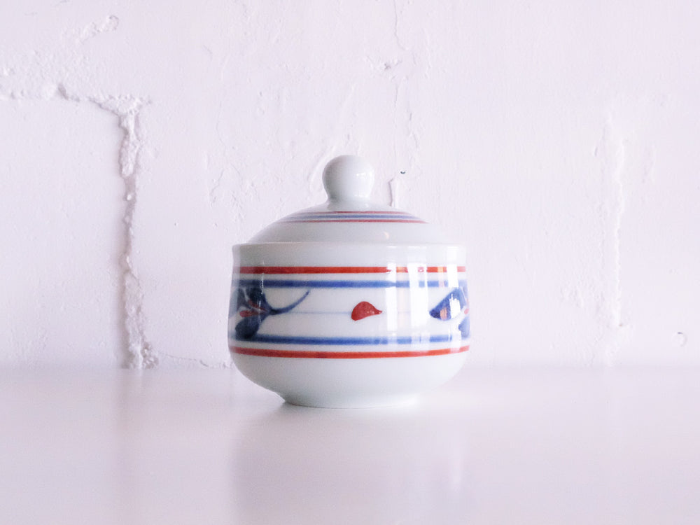 
                  
                    Lidded Red Line and Mitsuba Patterned Pot by Baizan-gama
                  
                